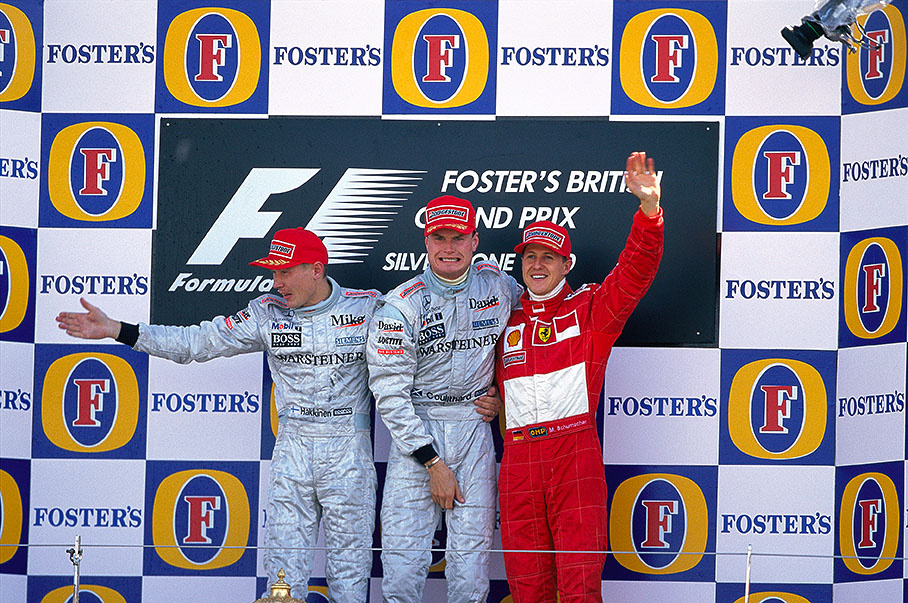 Winner David Coulthard celebrates with team-mate Mika Hakkinen and Michael Schumacher