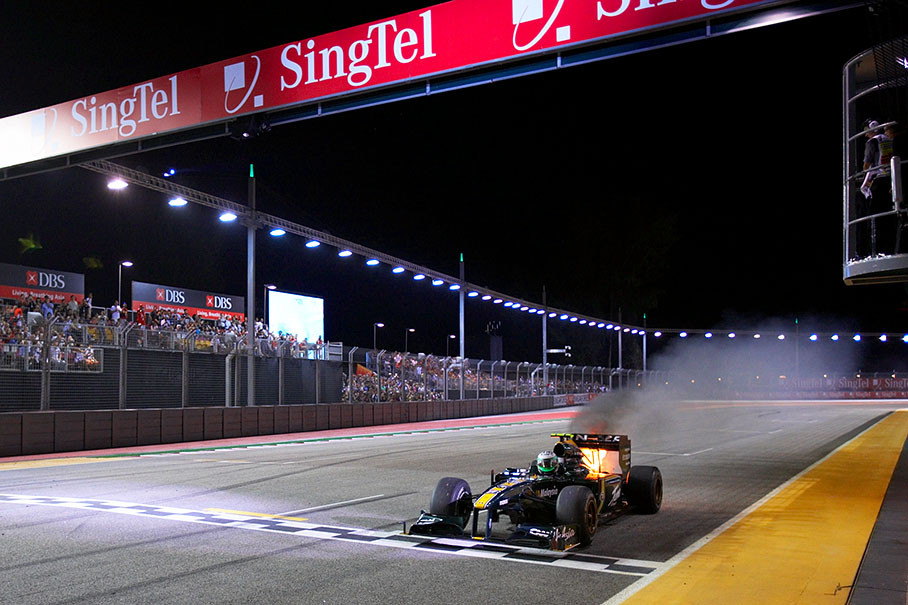 Heikki Kovalainen's Lotus-Cosworth crosses the finish line with a burning rear 3 laps before the end of the race