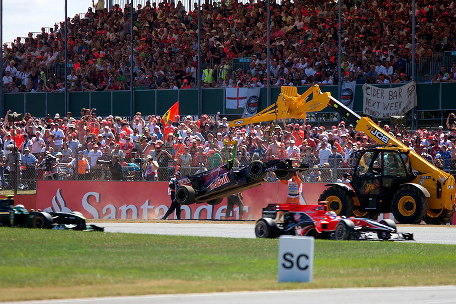 Alguersuari's Toro Rosso is being towed away from the gravel trap at the final corner and is out of the race
