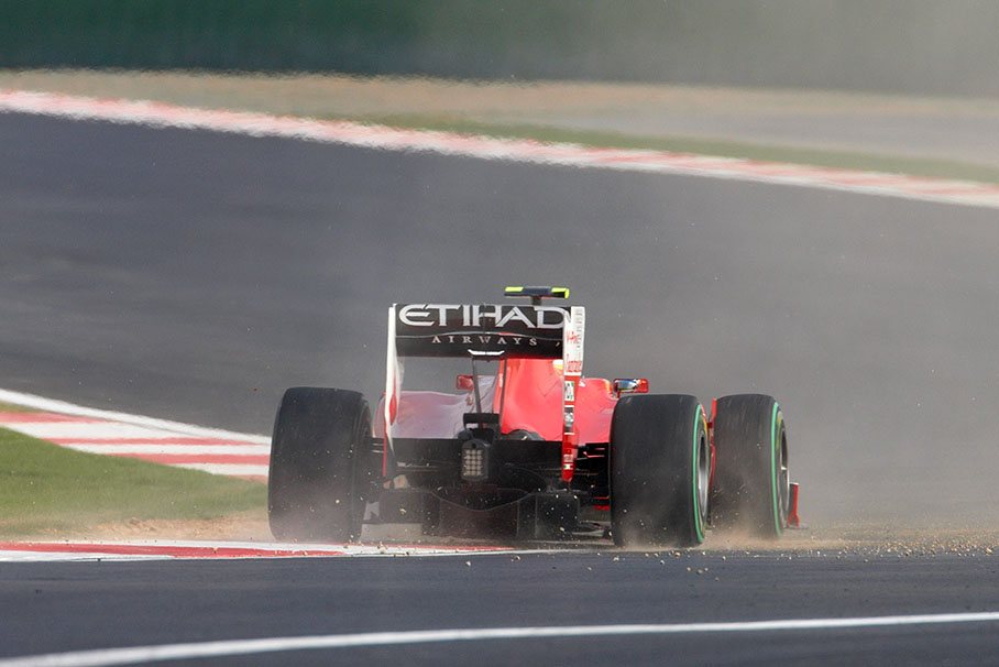 Fernando Alonso, Ferrari, raises dust at the damaged curb in the last turn