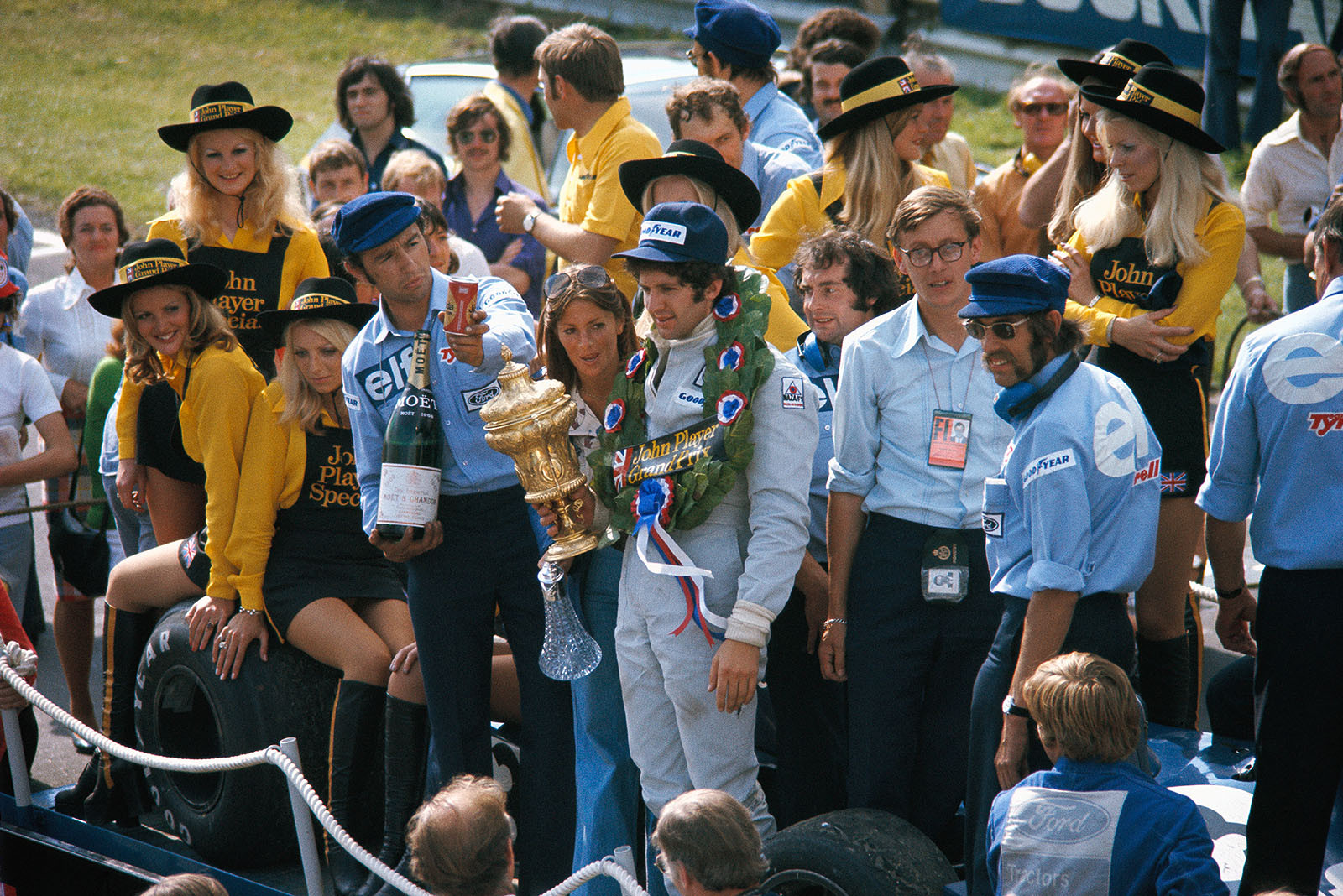 Tyrrell driver Jody Scheckter on his parade lap after winning the British Grand Prix at Brands Hatch 1974. Jo Ramirez is about to offer him a soft drink.