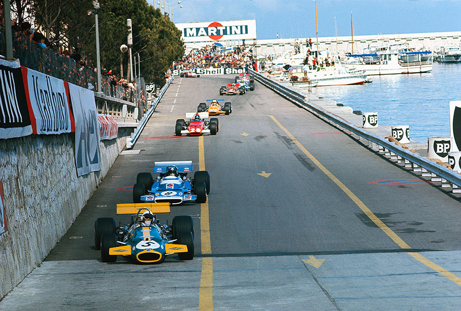 Queue of F1 cars between tunnel exit chicane and Tabac, Jack Brabham in the lead in front of Pescarolo and Ickx