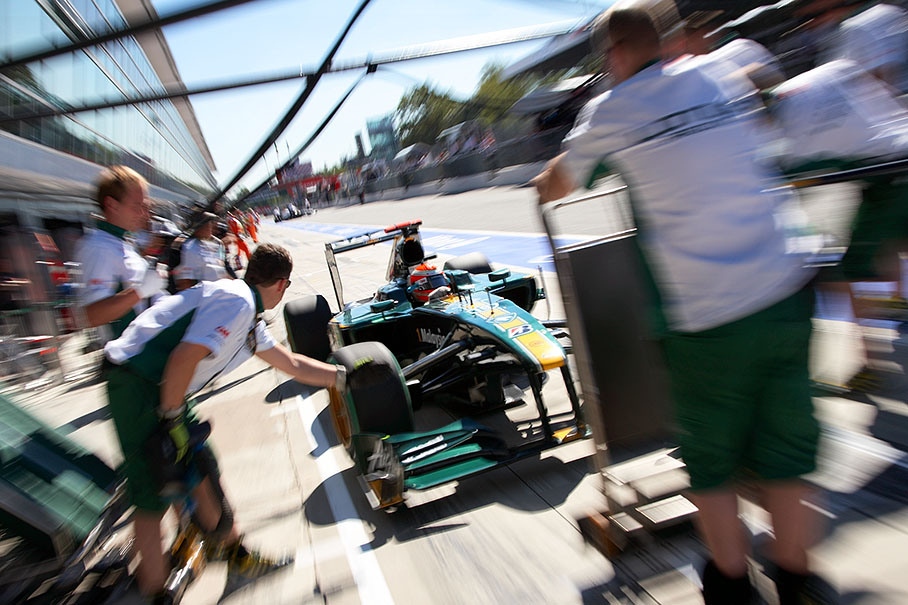 Jarno Trulli practises pit stops with the Lotus pit crew