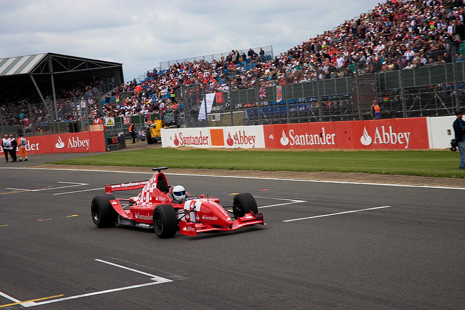 Mick Jagger's daughter Jade getting a ride by The Stig in a two-seater formula car.