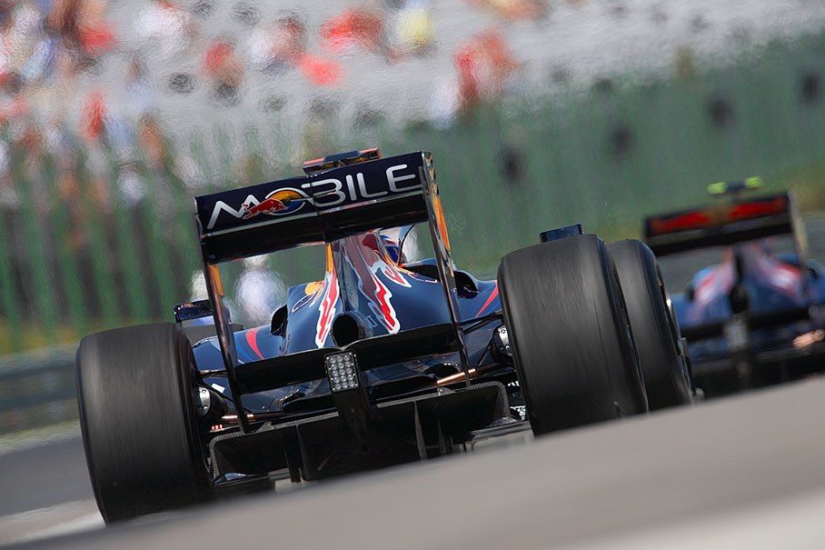 Mark Webber, Red Bull Racing, leaves pit lane behind a Toro Rosso car
