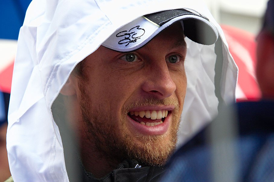 Jenson Button waits for the start of a rainy drivers parade