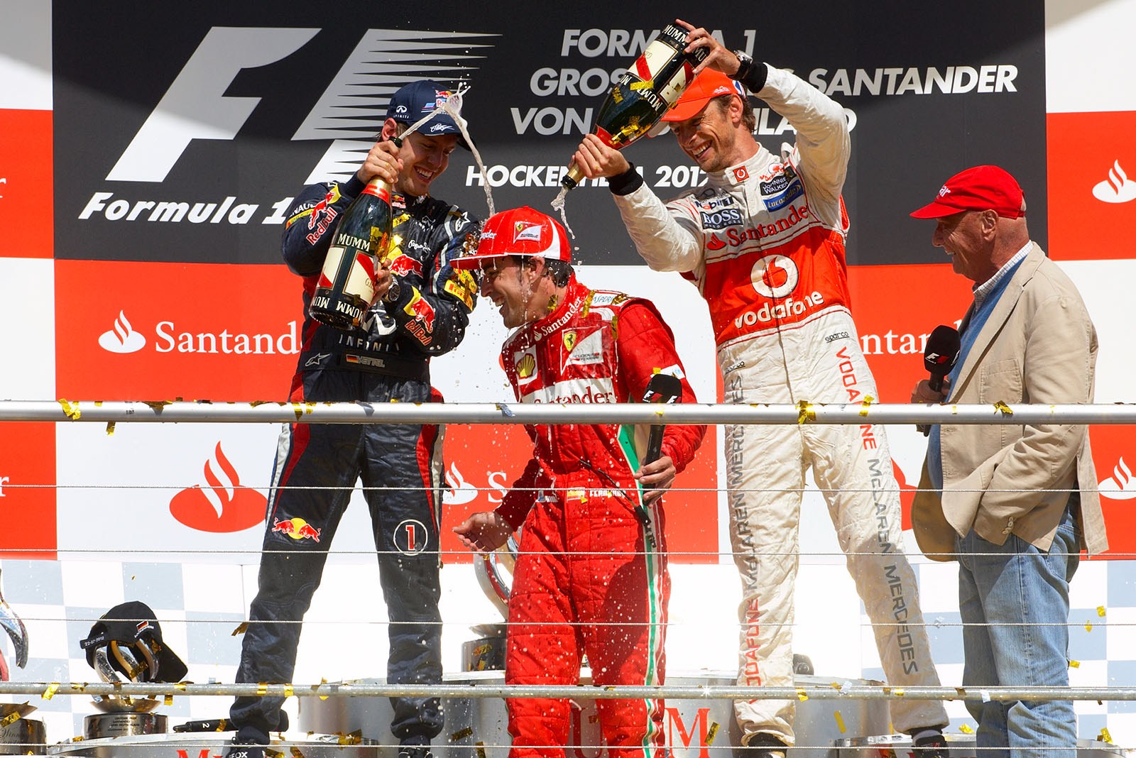 Race winner Fernando Alonso enjoys a champagne shower of Sebastian Vettel and Jenson Button on the podium after the German Grand Prix
