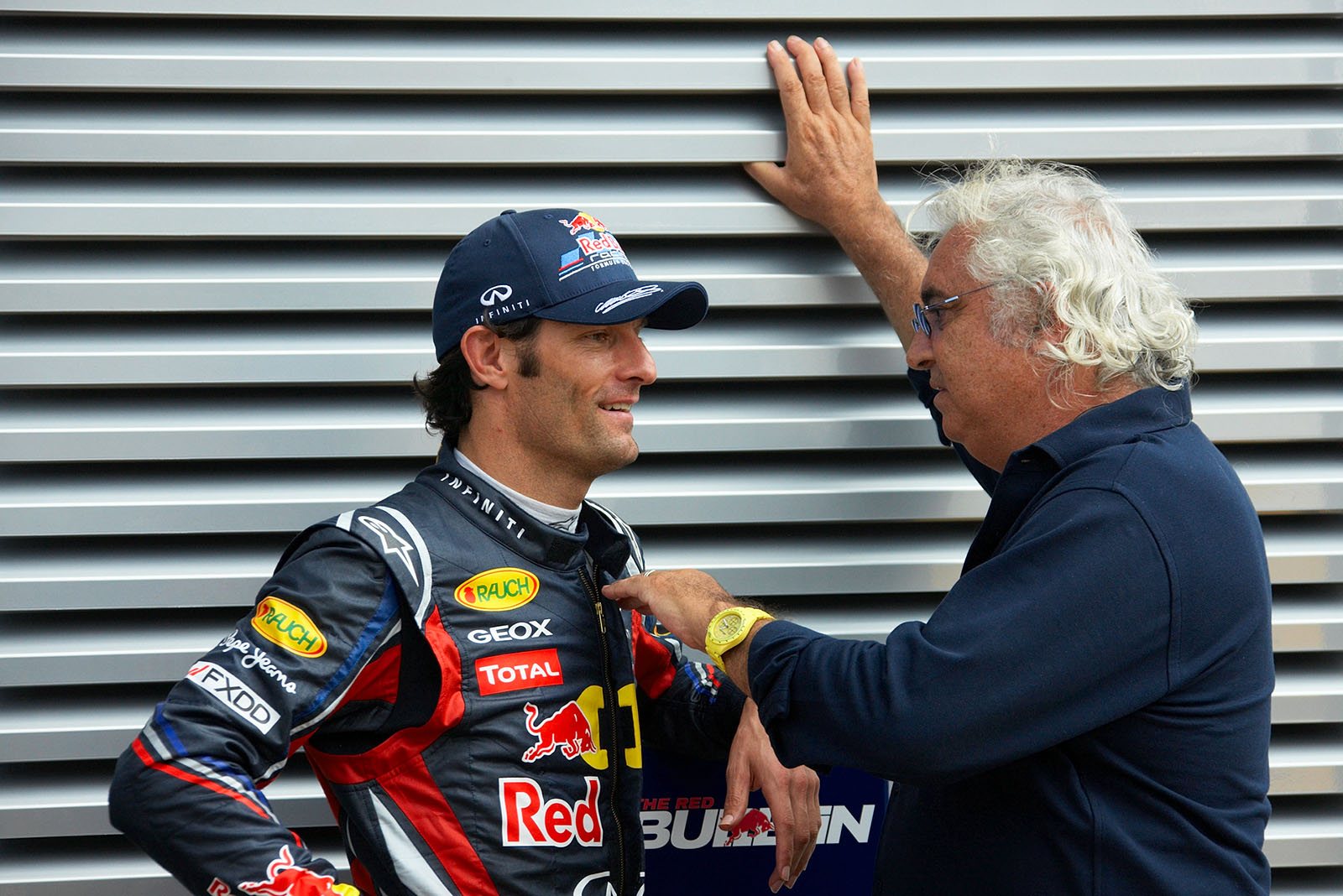 Former Renault team boss Flavio Briatore chats with Mark Webber in the paddock
