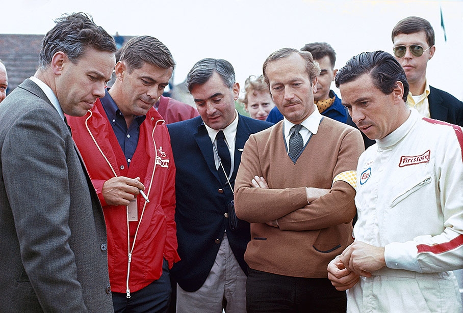 Lotus driver Jim Clark in a exchange of words about the new Cosworth V8 engine with Keith Duckworth, a tyre expert of Firestone, Walter Hayes of Ford and Lotus team boss Colin Chapman.