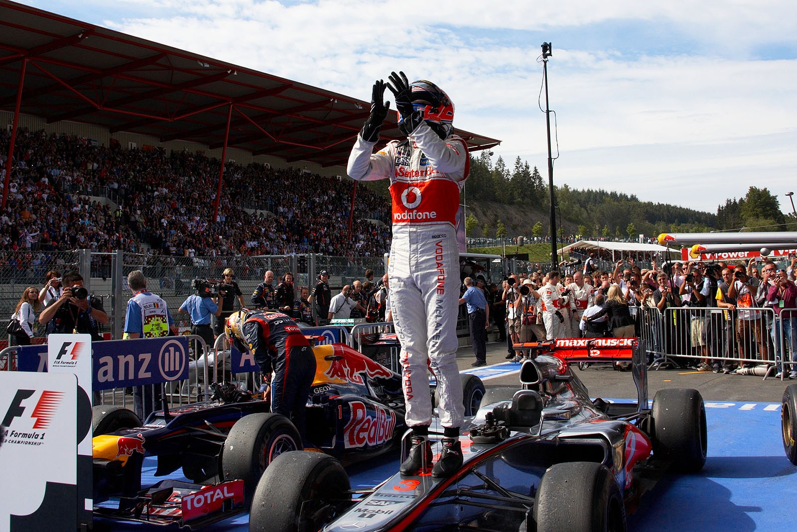 Race winner Jenson Button of McLaren Mercedes celebrates on his race car in parc ferme