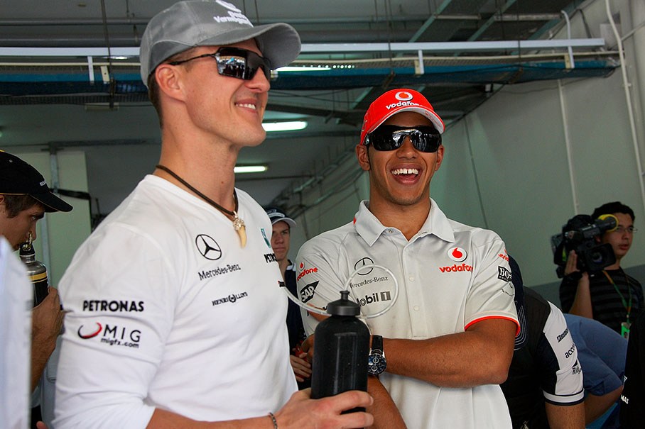 Michael Schumacher and Lewis Hamilton exchange jokes before the drivers parade