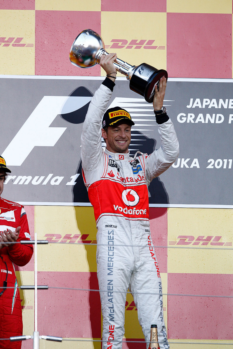 Race winner Jenson Button of McLaren presents his trophy