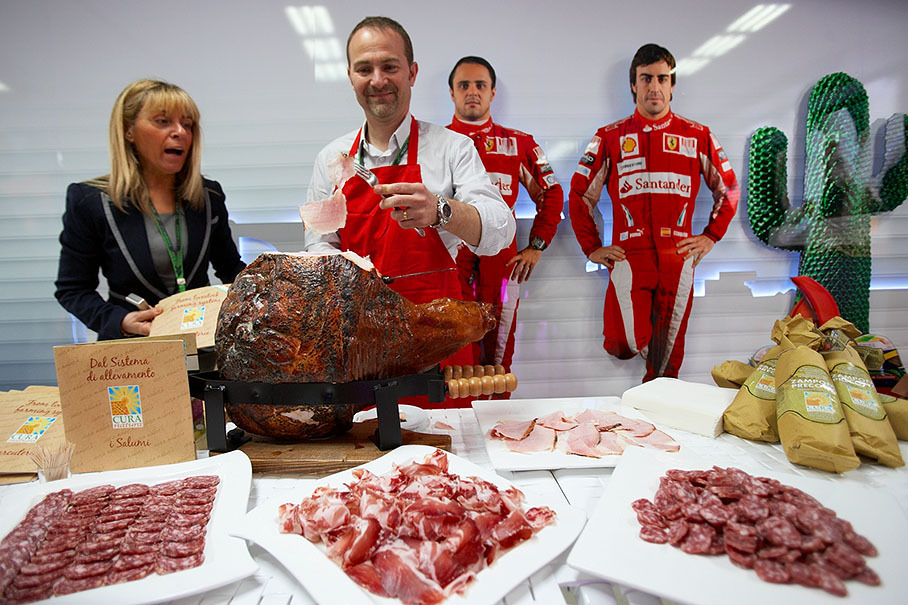 Ferrari proves tuscan hospitality with yummy bio ham and puppets of Massa and Alonso