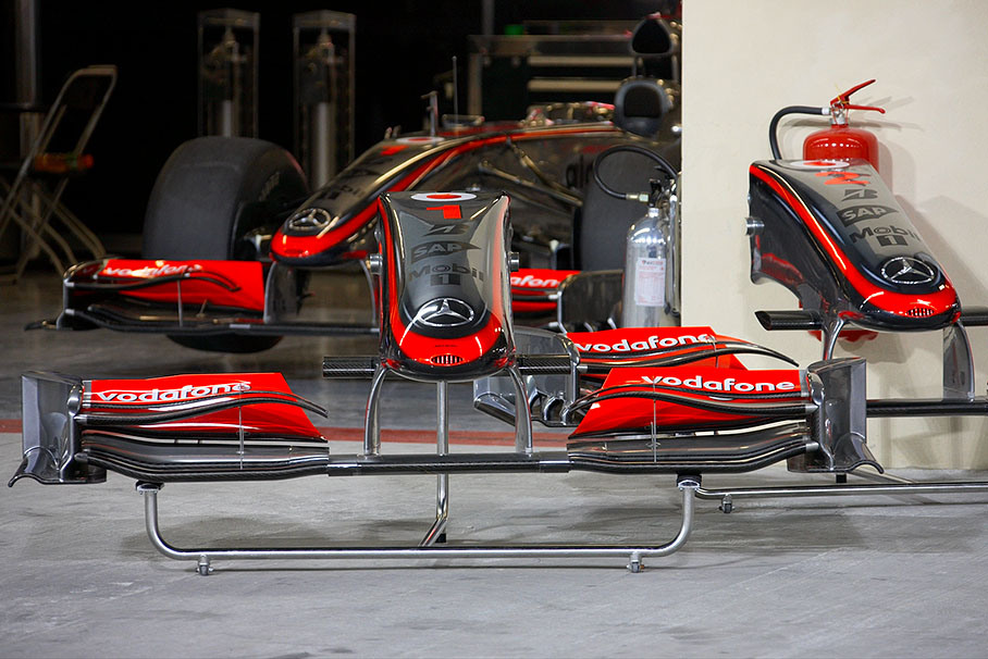 McLaren nose cones and front wings in front of the pits guard Hamilton's retired car