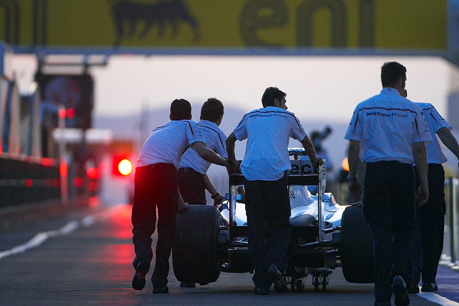BMW Sauber mechanics return the car to pits after scrutineering