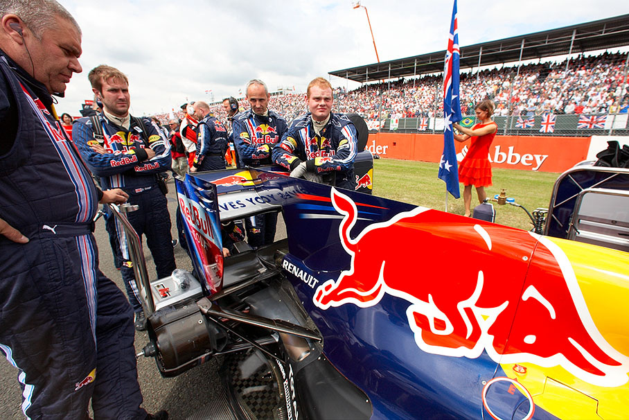 Red Bull mechanics wait at the car on the grid