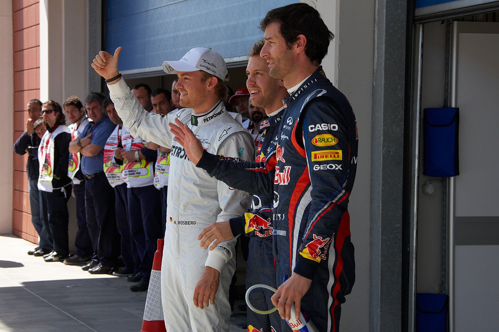 The fastest three qualifiers wave at the world's media: on the left hand third qualified Nico Rosberg of Mercedes, Red Bull driver Sebastian Vettel as polesetter in the middle and his team mate Mark Webber as second on the grid