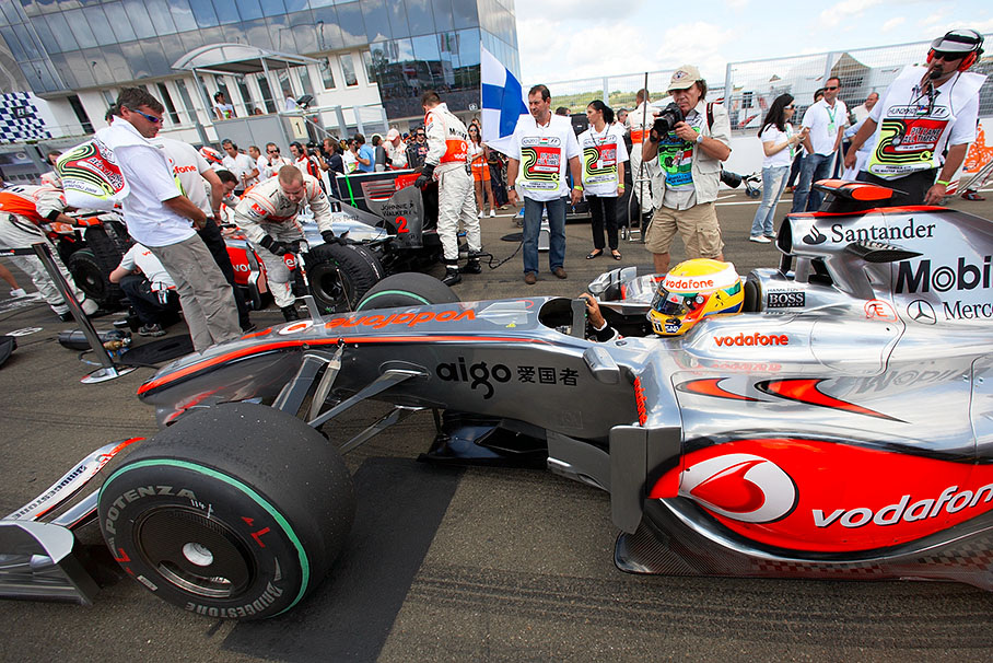 Photographer Paul-Henri Cahier takes a photo of Hamilton's McLaren Mercedes