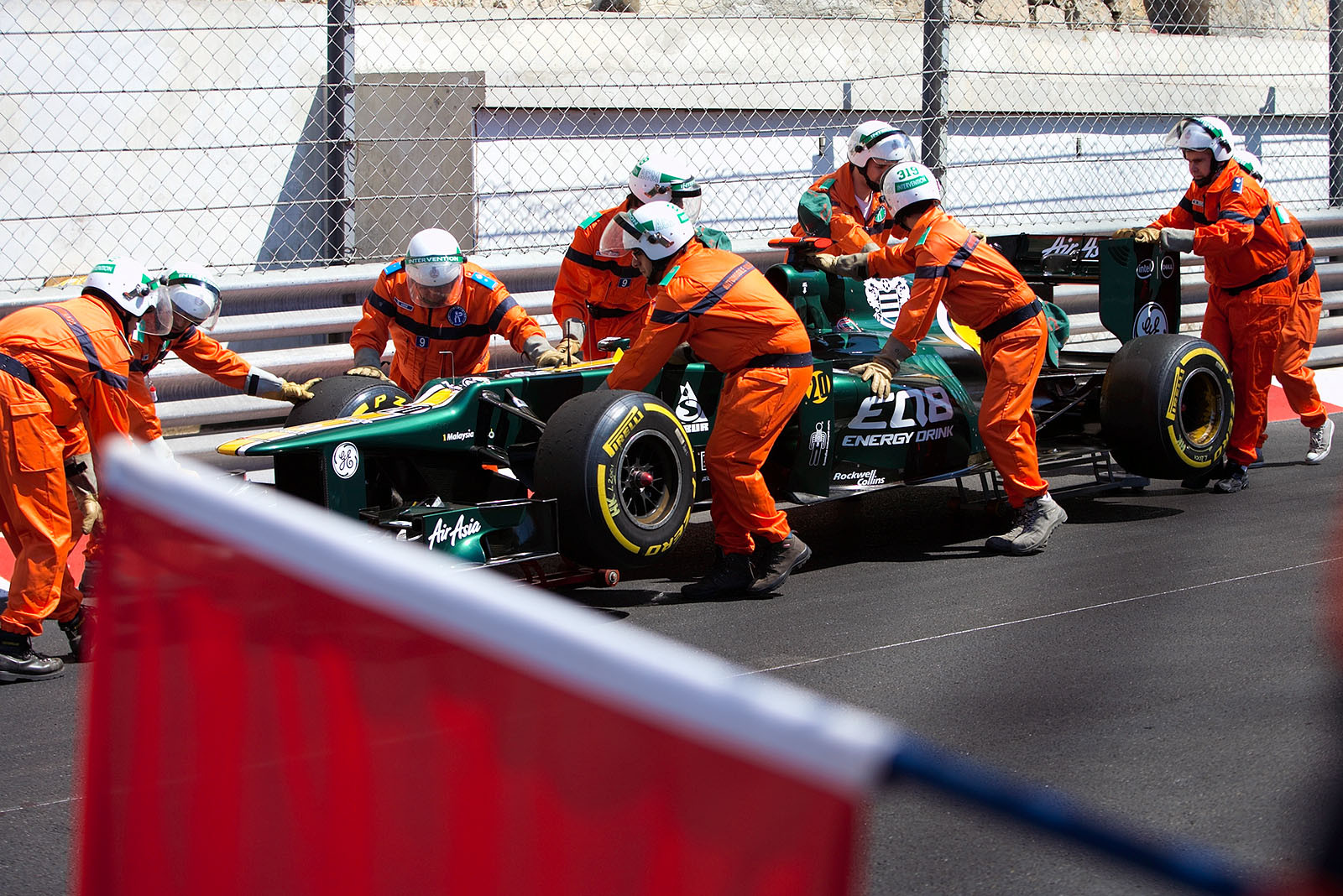 Heikki Kovalainen's Caterham is secured by the marshals at the tunnel exit