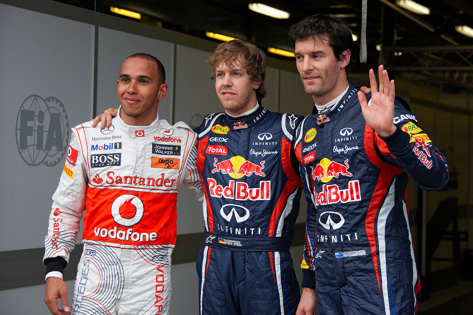 The fastest three qualifiers wave at the world's media: on the left hand second qualified McLaren's Lewis Hamilton, Red Bull driver Sebastian Vettel as polesetter in the middle and his team mate Mark Webber as third on the grid
