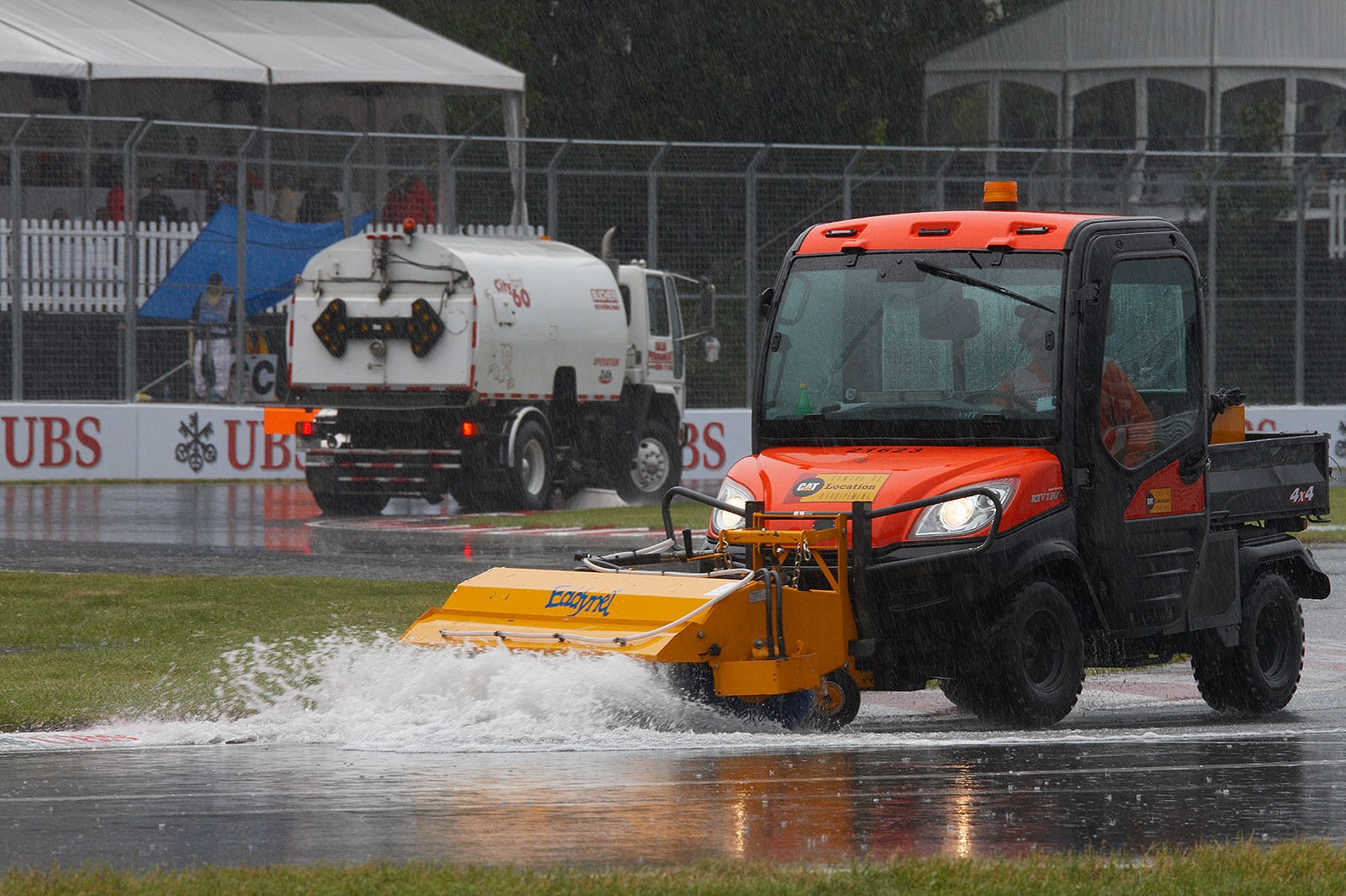 Rain water is pushed from the race track whilst the race is suspended