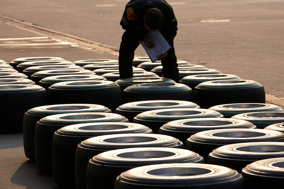 Tyres are being checked in the evening sun shining on the paddock, strictly in line, too