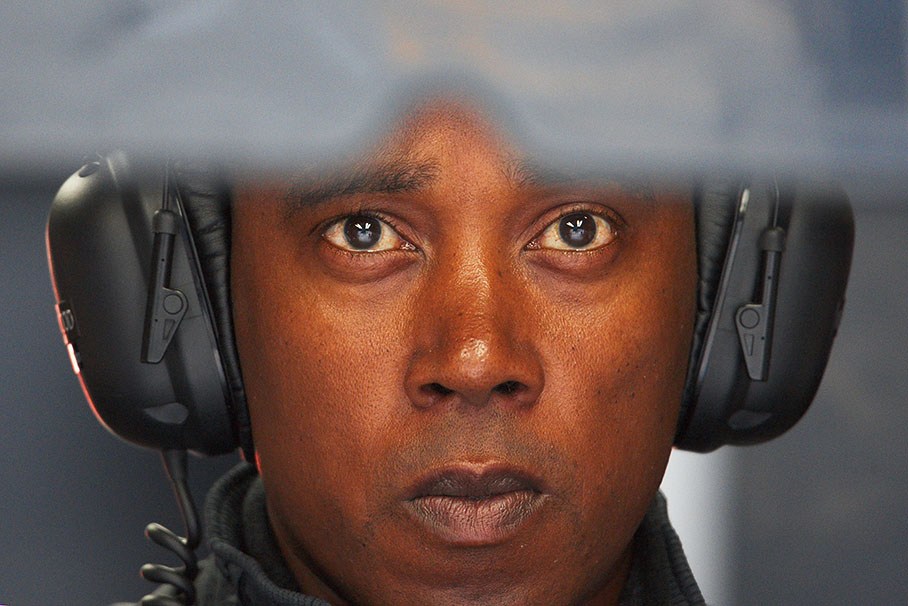 Lewis Hamilton's father Anthony watches a times screen in pits