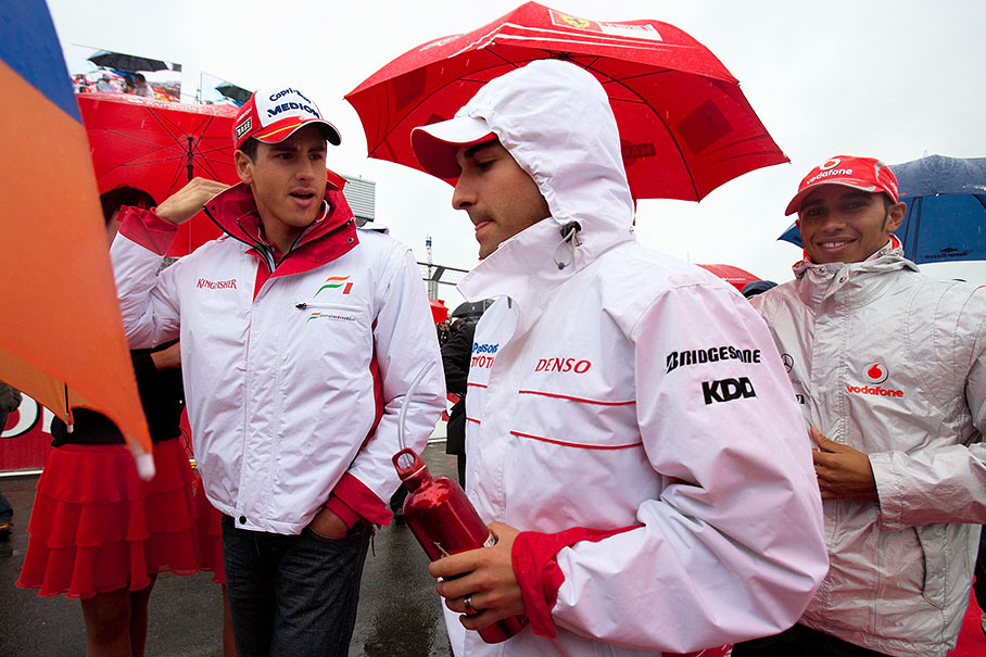 Whilst Sutil and Glock chat on their way to drivers parade, Hamilton smiles at the camera
