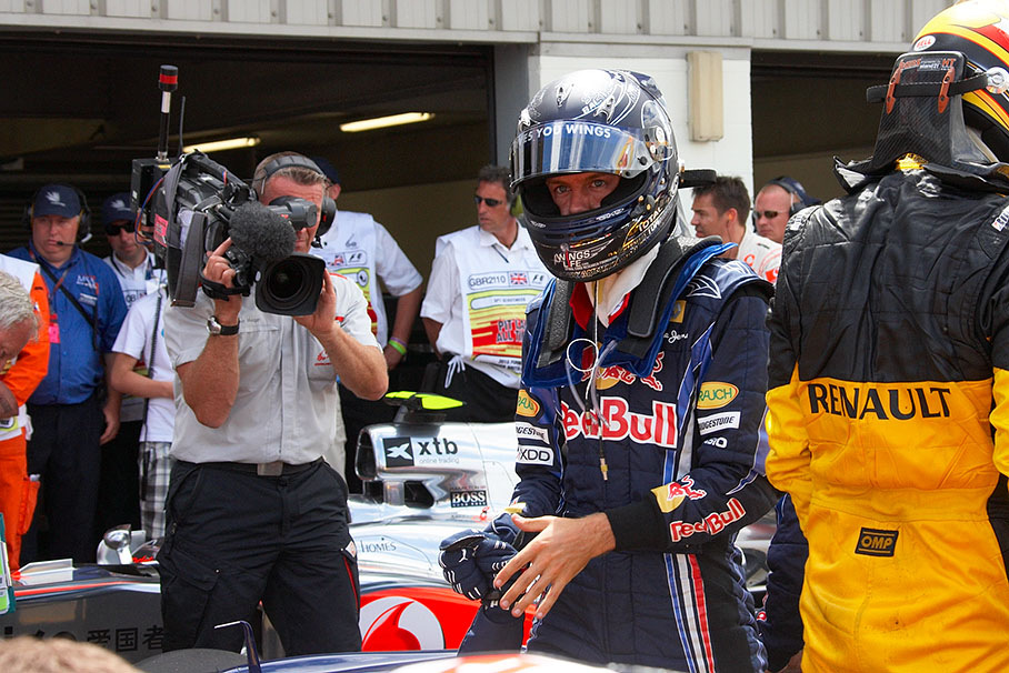 Polesetter Vettel still with helmet on in parc ferme after qualifying