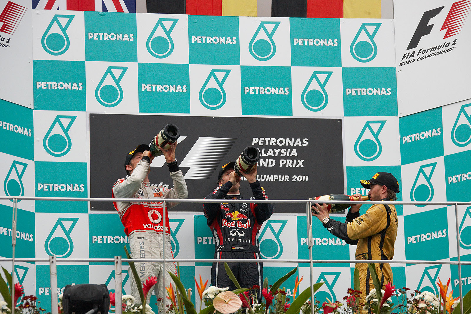 A last sip of champagne on the podium after the Malaysian GP for second placed Jenson Button of McLaren, Red Bull's race winner Sebastian Vettel and third placed Nick Heidfeld of Renault