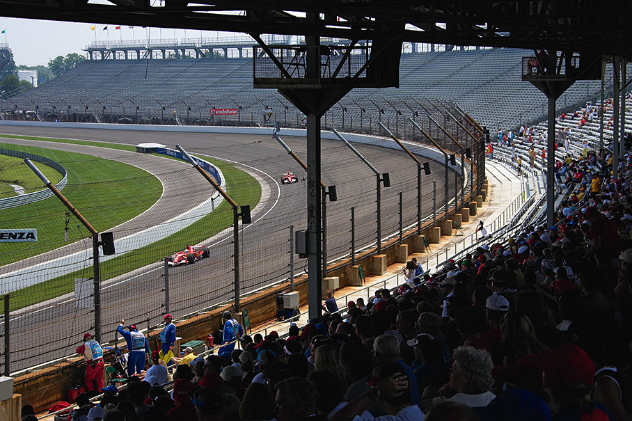 Both Ferraris racing in the oval, passing an empty grandstand