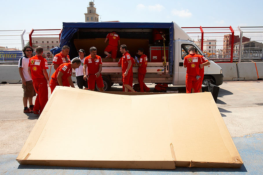 Ferrari mechanics unload the van which delivered new carbon fibre car body parts