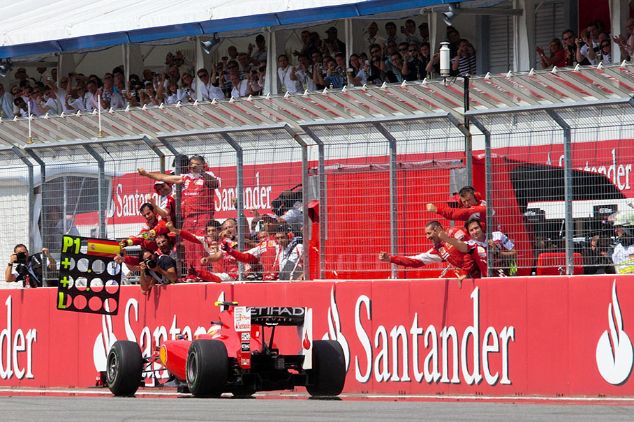 Fernando Alonso passes a cheering Ferrari team