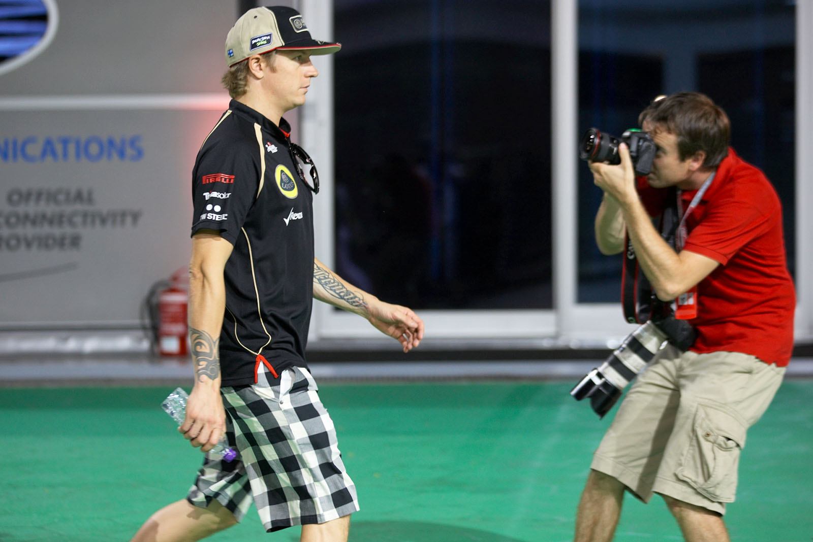 Kimi Raikkonen, Lotus F1 team, walks in the paddock (with cautious photographer Mirko Stange)