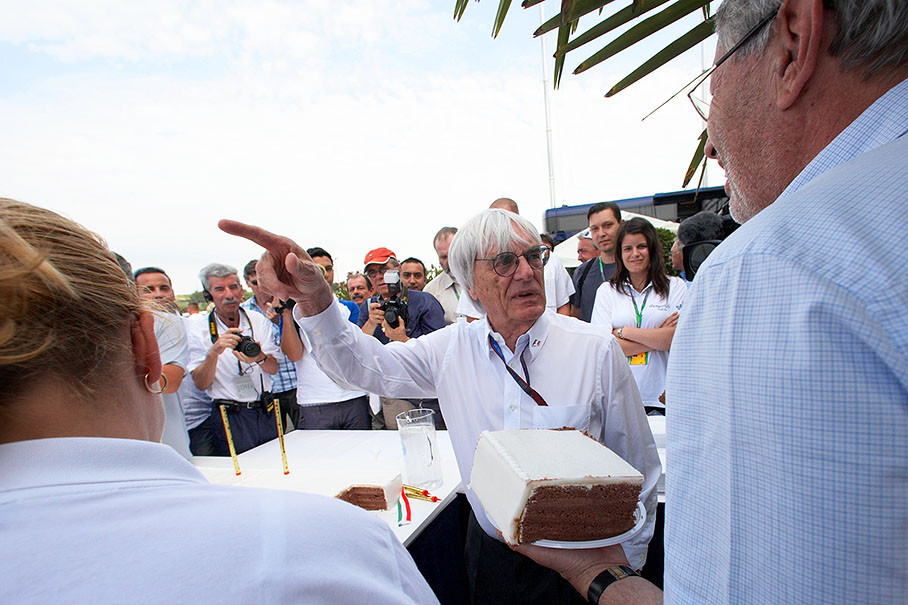 Bernie Ecclestone receives a piece from the huge cream pie of Hungaroring's 25th anniversary from the track's Vice President Tamas Frank