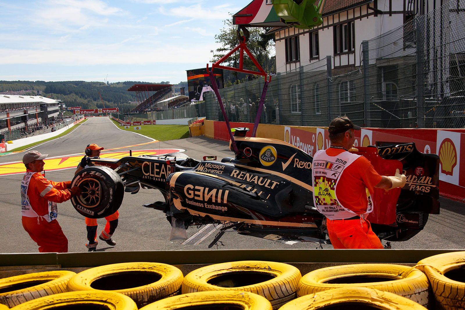 Romain Grosjean's Lotus Renault is towed away after the start accident in turn one