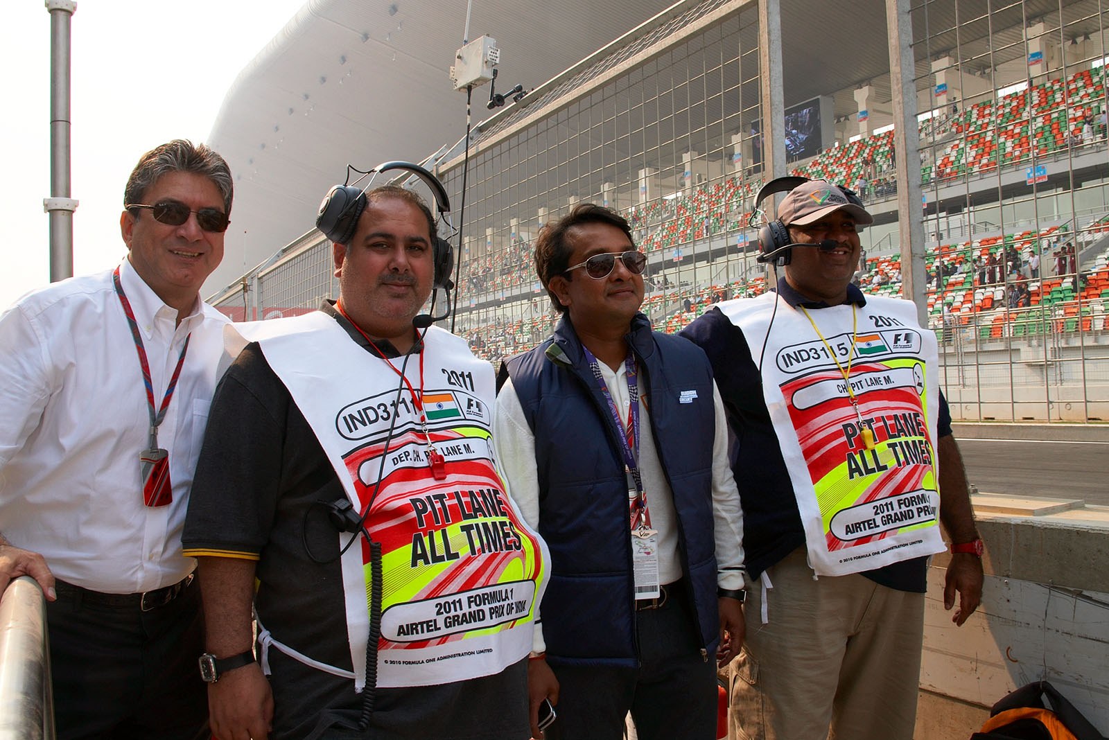 FOM's Pasquale Lattuneddu poses with Samir Gaur, CEO of the race organising Jaypee Sports agency, and two pitlane marshals