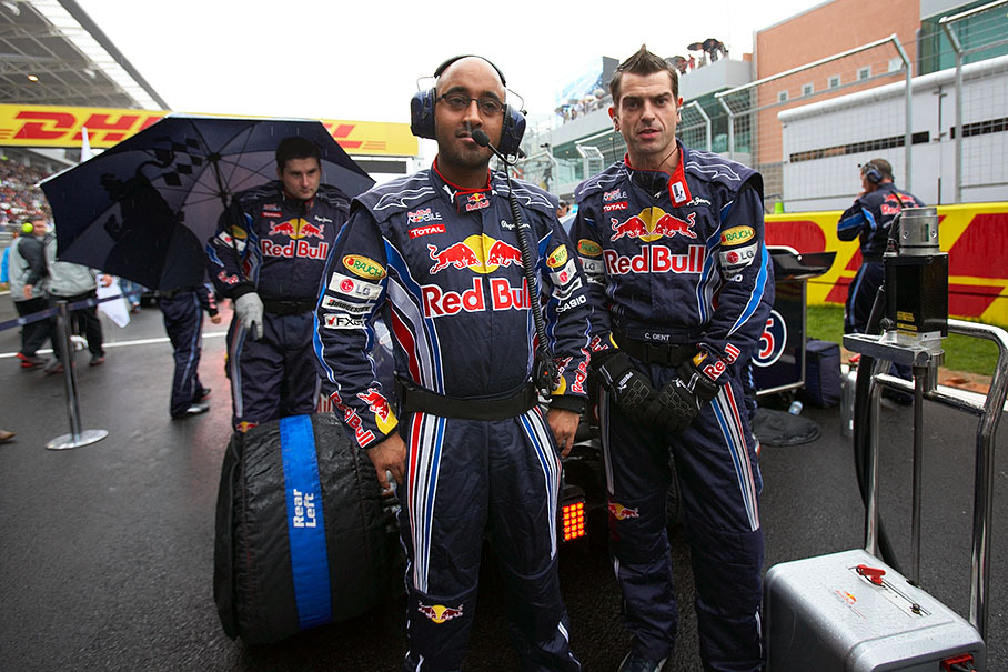 Red Bull mechanics guard their Red Bull-Renault car against curious views on the grid