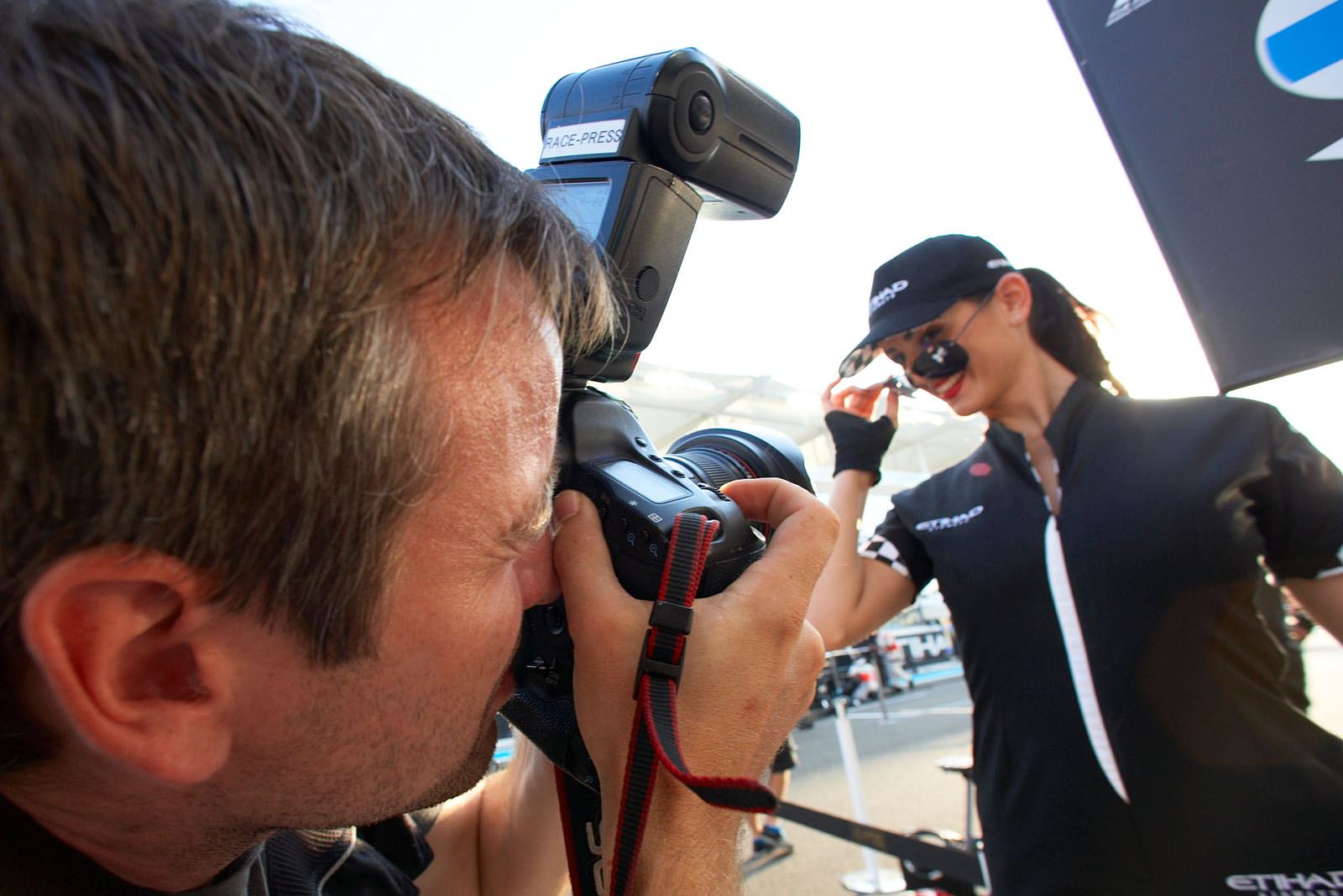 Race press photographer Mirko Stange takes a photo of a grid girl