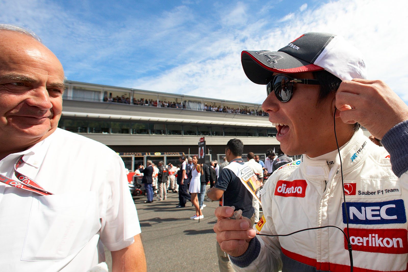 Sauber's Kamui Kobayashi chats with caterer Karlheinz Zimmermann on the grid before the race