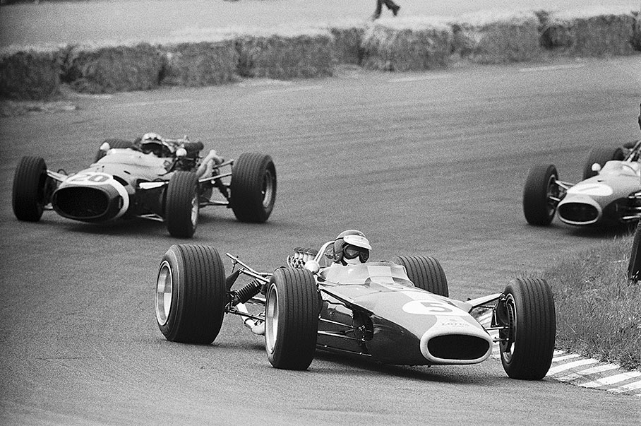 Jim Clark, Lotus Ford-Cosworth 49, performes a nice drift through the left hander "Hugenholtzbocht", closely followed by backmarker Siffert in a Cooper while Brabham (no. 1) can't keep up with the Lotus' speed