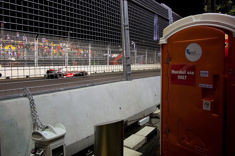 The secured toilets besides the track were reserved for the marshals (Hamilton passes in the back)