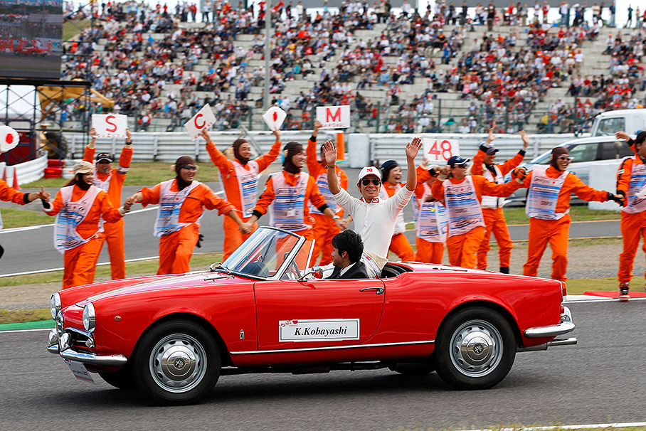 Local hero Kamui Kobayashi waves at the fans from a historic car during the drivers parade