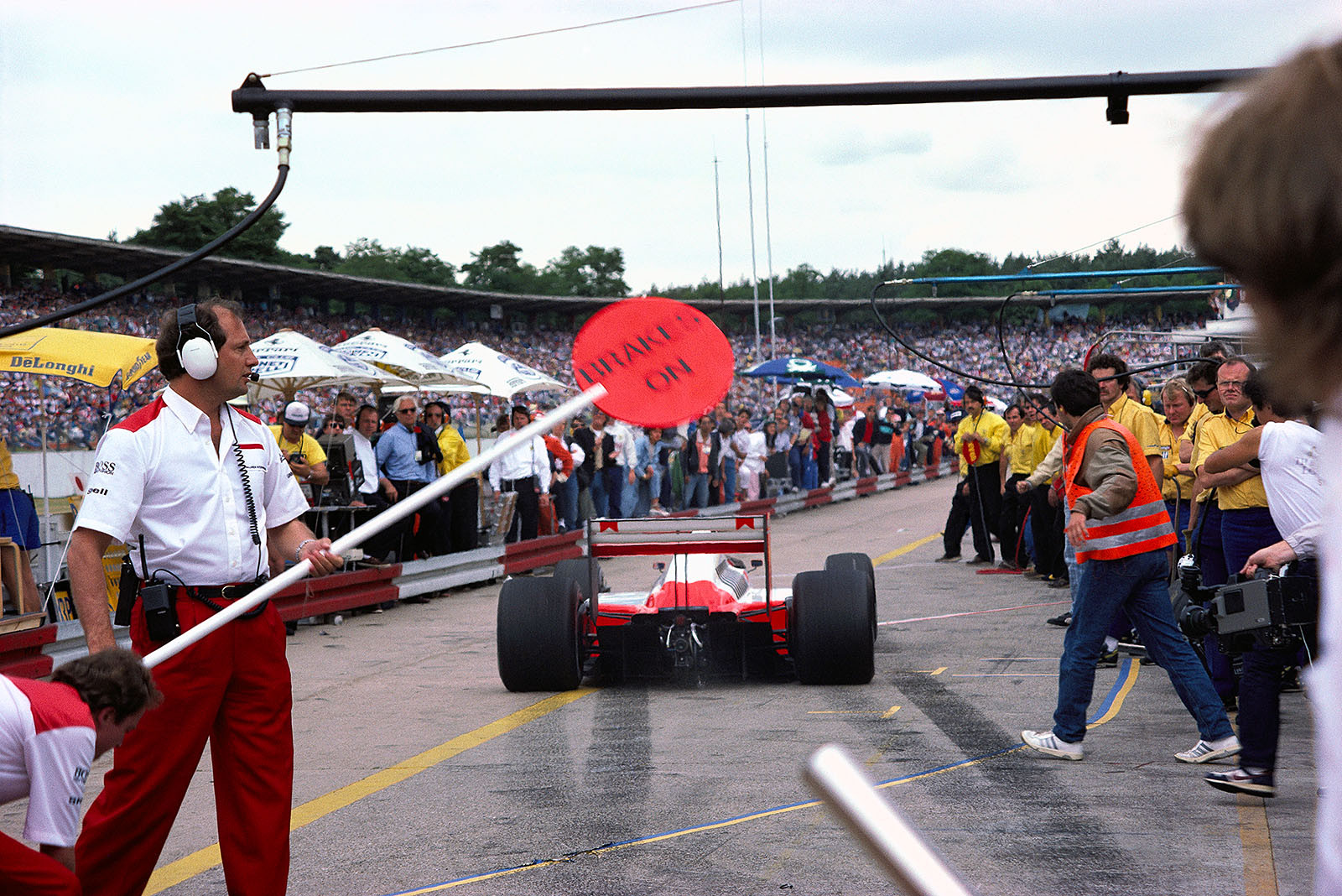 After a pit stop for tyre change, McLaren team boss Ron Dennis gives way to his second placed driver Stefan Johansson, German Grand Prix, Hockenheim, 1987