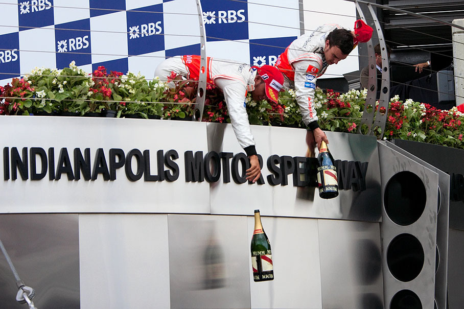 Lewis Hamilton and Fernando Alonso share the champagne with their team
