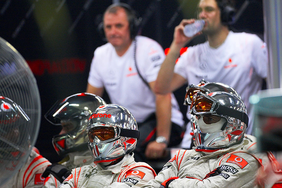 McLaren engineers and mechanics watch the race on a screen in pits