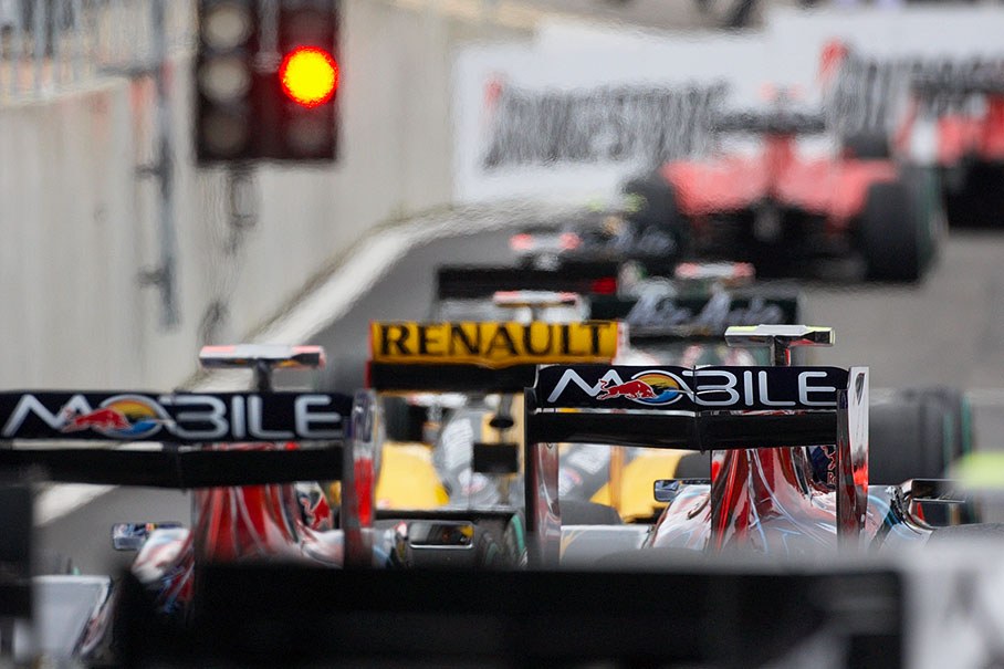 F1 cars wait in line for green lights at the end of the pit lane