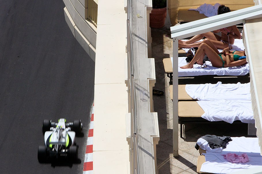 Rubens Barrichello, Brawn Grand Prix, passes some sunbathing beauties