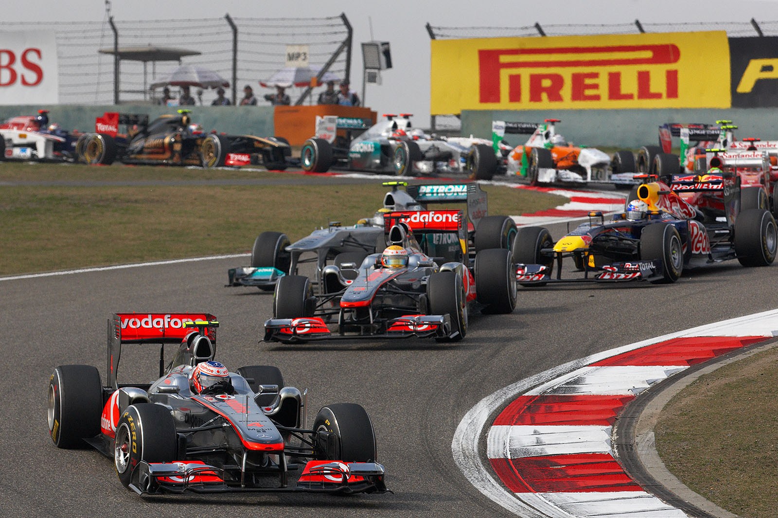 After a fabulous start, the McLarens lead the field through the first chicane with Jenson Button in front, followed by team mate Hamilton, then Vettel and Rosberg