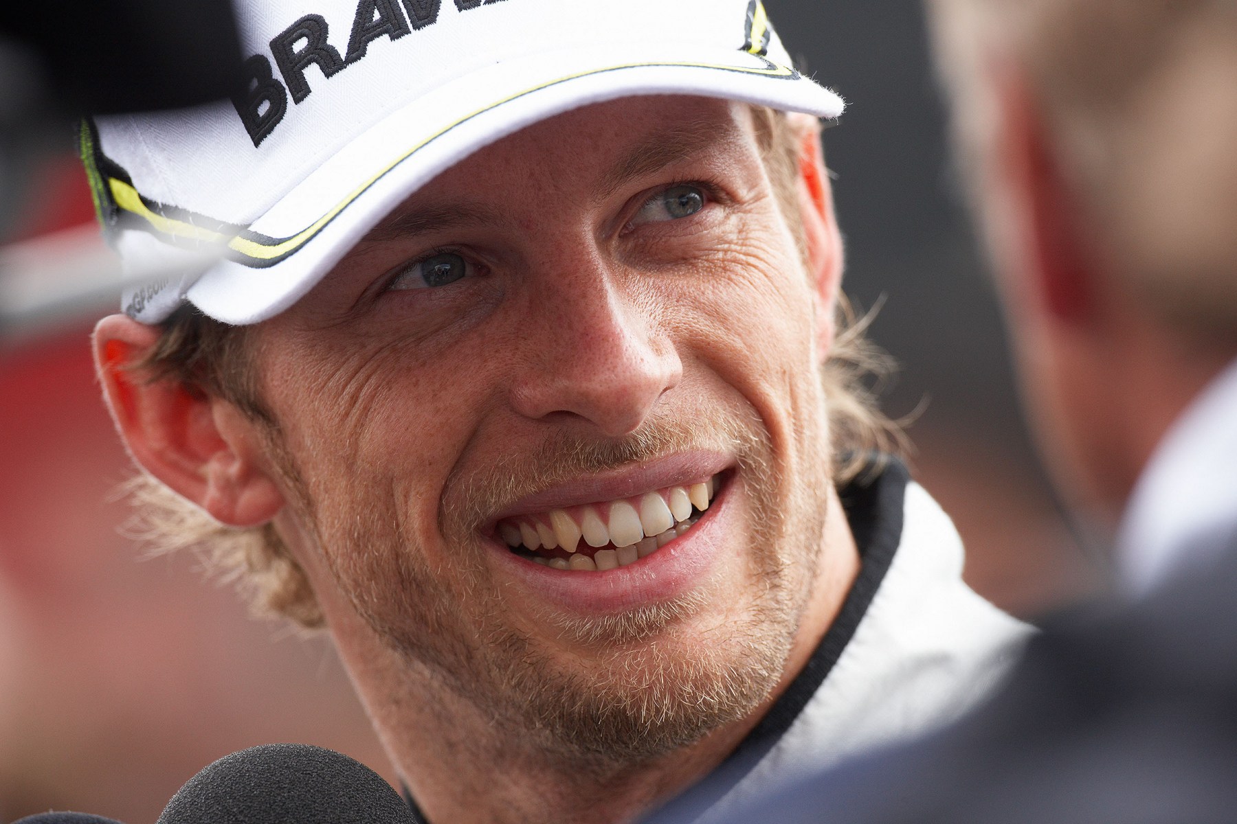 Jenson Button is being interviewed, looking confident despite having qualified on sixth grid position